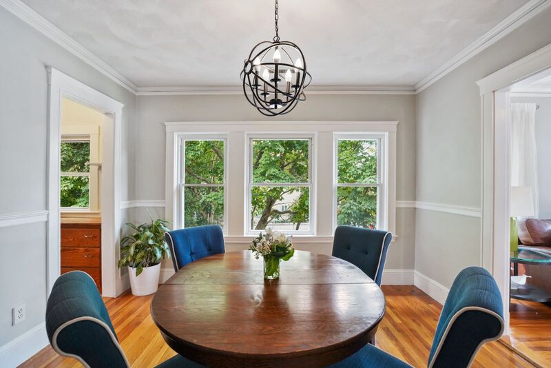 Dining room with 3 large windows, showing living room to the right and pantry to the left.